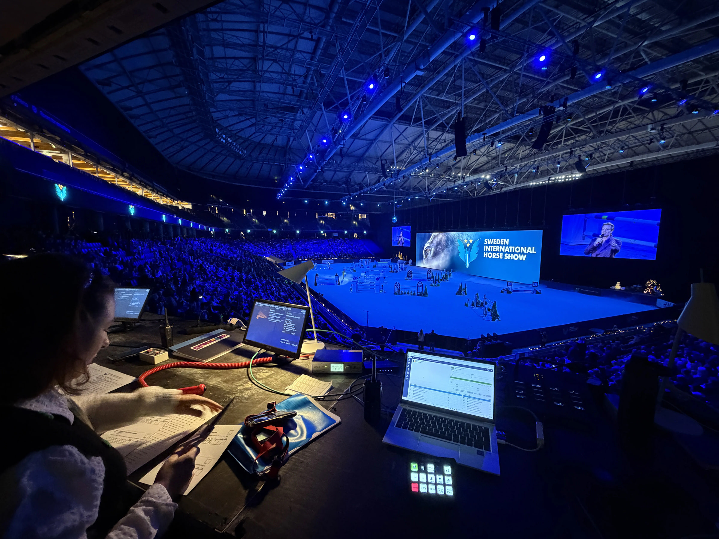 Produktionsplats med operatör, monitorer och arena under Sweden International Horse Show